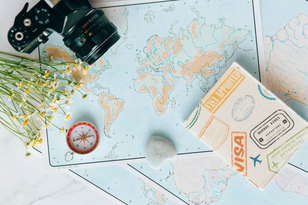 Carte, passeport et accessoires disposés pour organiser un voyage de plusieurs mois